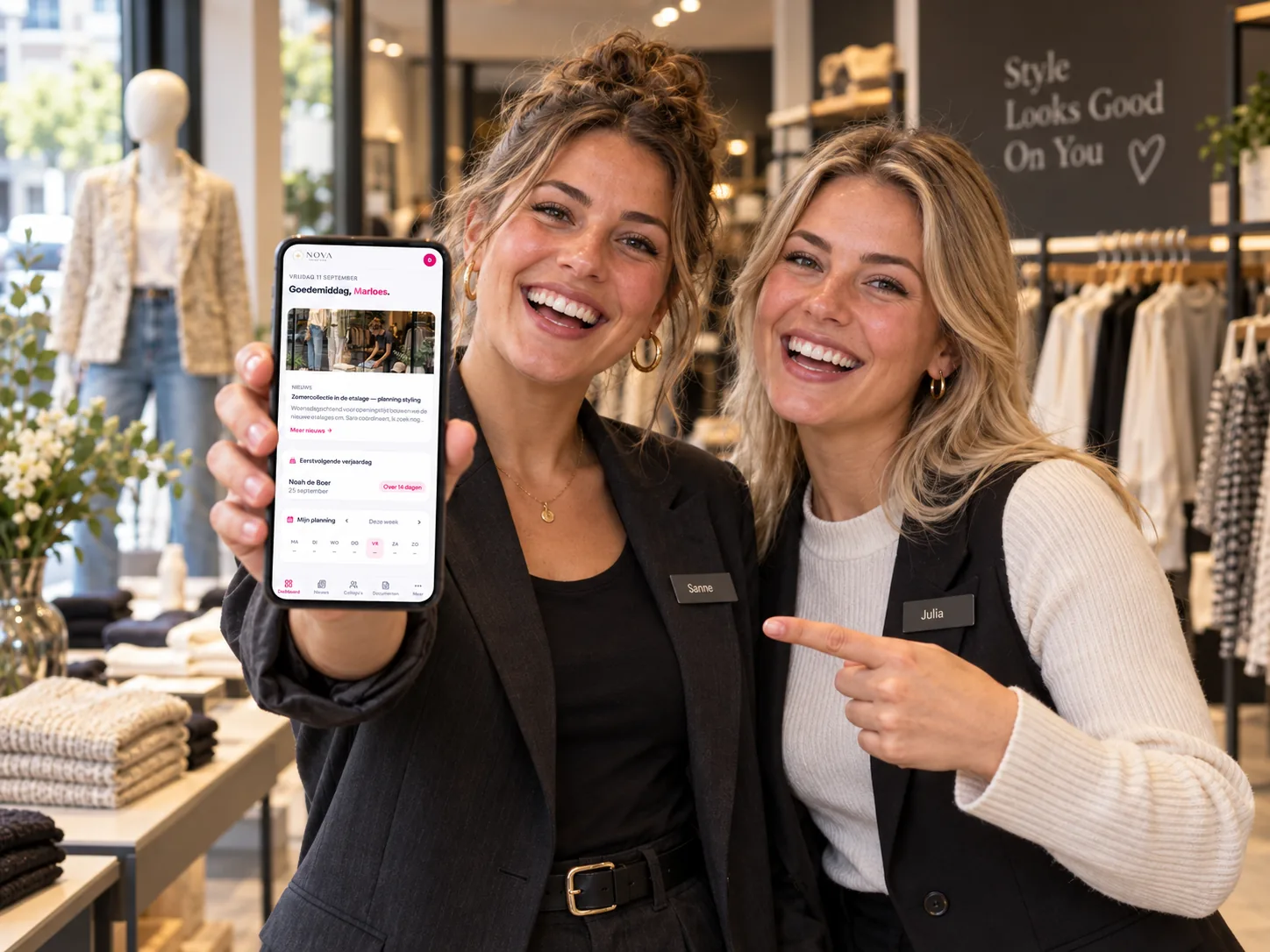 Twee winkelmedewerkers bekijken samen hun planning in de MijnPloeg-app.